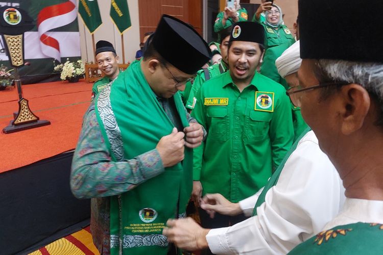 Gubernur DKI Jakarta Anies Baswedan saat dikalungi sorban oleh Ketua Majelis Syariah DPW PPP DKI Munawir Aseli di salah satu hotel di Jakarta Barat, Minggu (25/9/2022) malam.