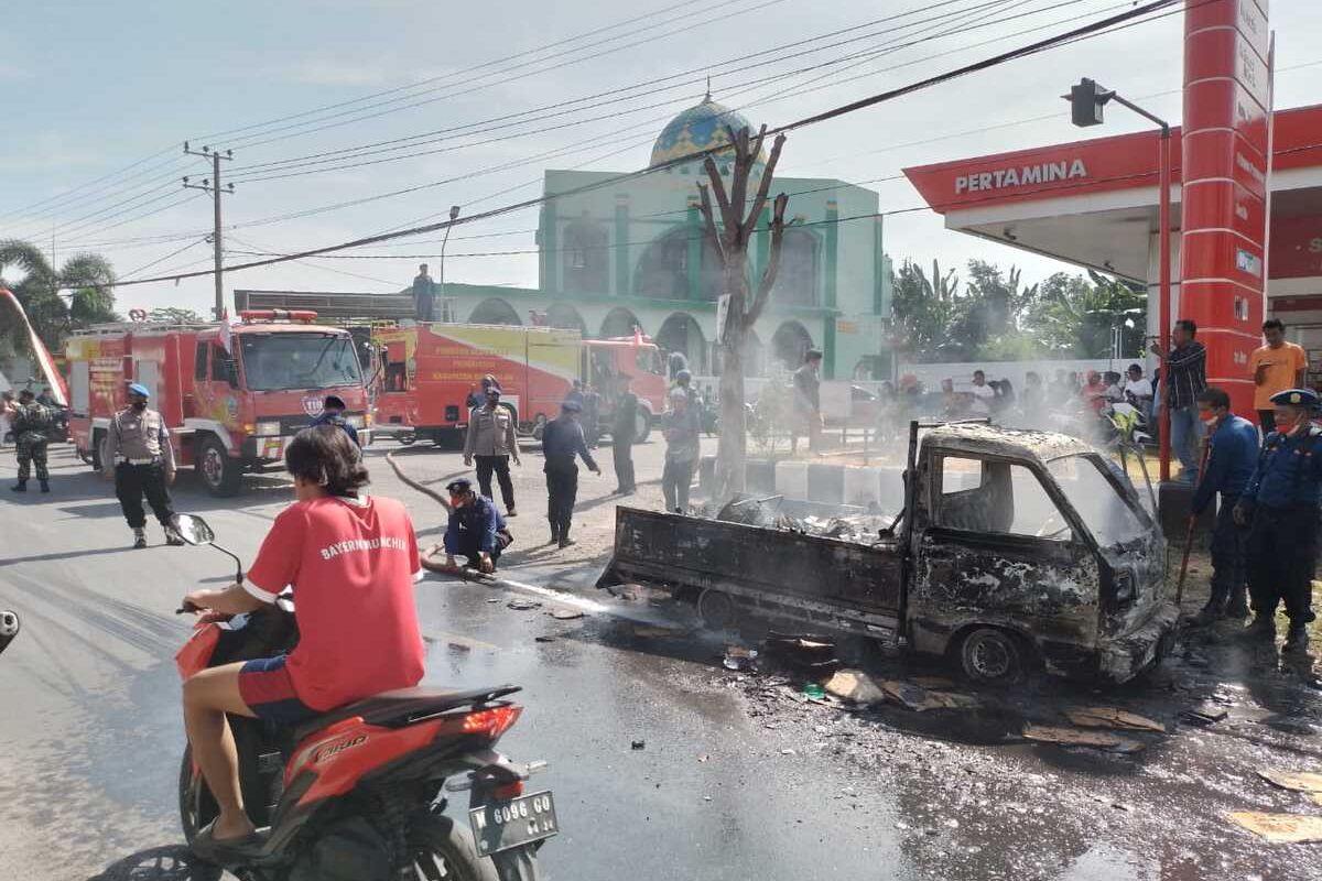 Petugas gabungan saat memadamkan api pada mobil pikap yang terbakar di depan Pom Bensin Kamal, Bangkalan Madura Jawa Timur, Rabu (17/8/2022).