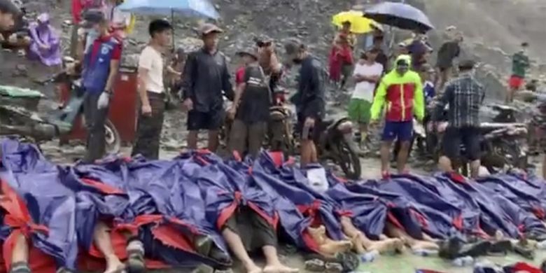 Dalam gambar yang dibuat dari video ini, orang-orang berkumpul di dekat mayat korban tanah longsor di dekat area penambangan batu giok di Hpakant, negara bagian Kachine, Myanmar utara Kamis (2/7/2020). Pemerintah Myanmar mengatakan tanah longsor di tambang batu giok telah menewaskan puluhan orang.