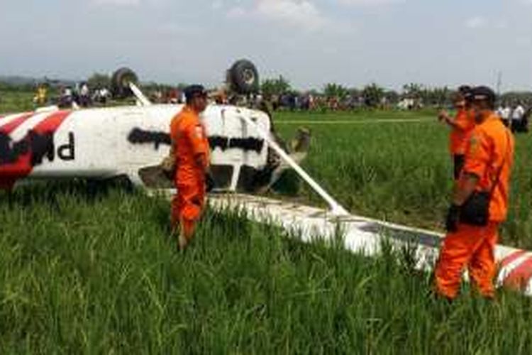 Anggota Basarnas Jawa Barat saat tengah memeriksa kondisi pesawat latih jenis Cesna yang jatuh di area pesawahan di Kabupaten Cirebon, Selasa (30/8/2016). Foto Dokumentasi Basarnas Jawa Barat.