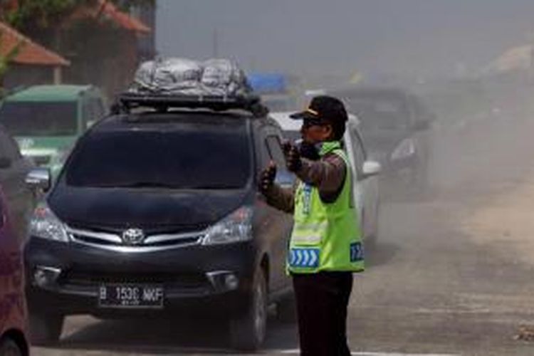 Polisi mengatur lalu lintas saat terjadi kemacetan di ruas Tol Pejagan-Brebes, Jawa Tengah, saat arus mudik H-6 menjelang Lebaran, Sabtu (11/7/2015). Tol Pejagan-Brebes dioperasikan untuk mengurangi kemacetan arus mudik Lebaran Idul Fitri 1436 H meski kondisi fisik jalan masih kurang baik. 