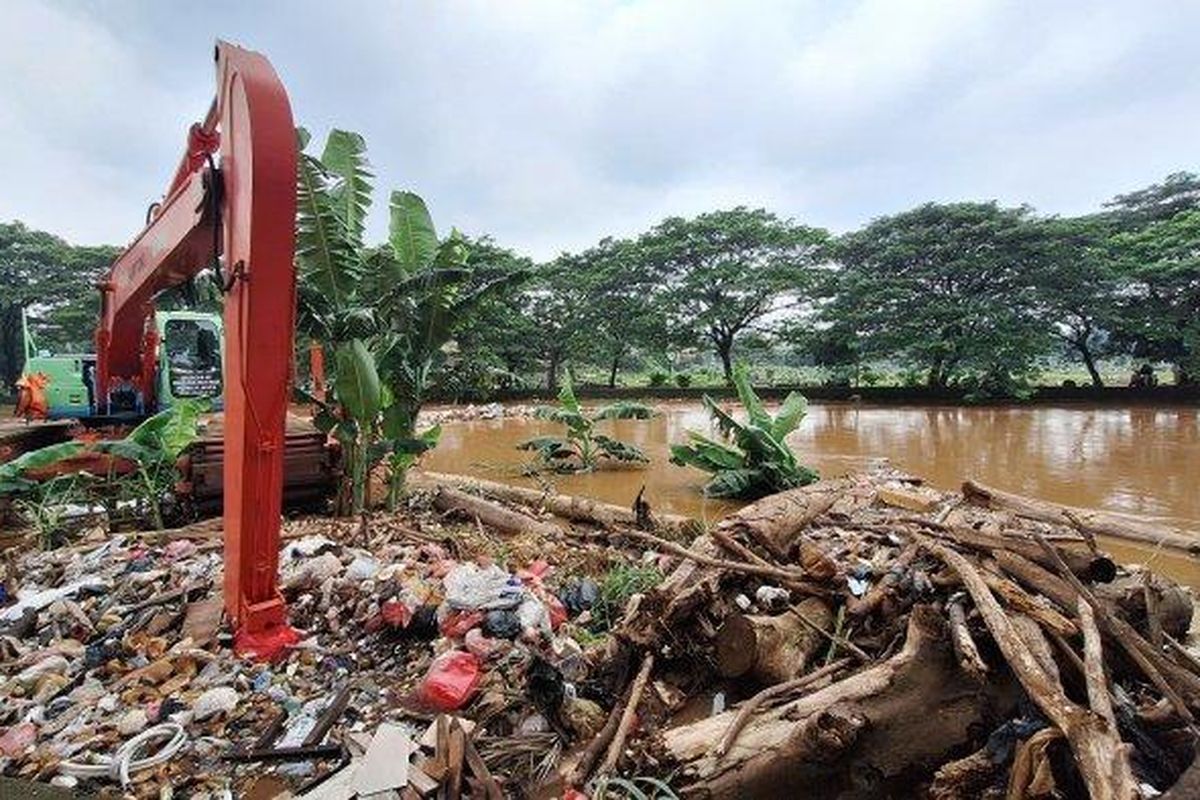 PETUGAS UPS BERJAGA - Petugas Unit Penanganan Sampah (UPS) Badan Air Lingkungan Hidup DKI Jakarta, Hamdari (kanan) bersama rekannya saat menjaga excavator yang berada di Kali Pesanggrahan, Tanah Kusir, Jakarta, Selasa (4/3/2025).