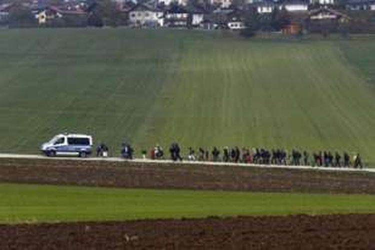 Para imigran dikawal polisi Jerman ke pusat registrasi setelah menyeberangi perbatasan Austria-Jerman di Wegscheid, dekat Passau, Jerman, 20 Oktober 2015.