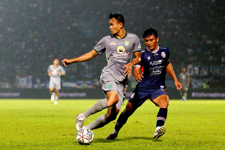 Pemain Persebaya Surabaya Koko Ari Araya dijaga ketat pemain Arema FC Irsyad Maulana saat pertandingan pekan ke-11 Liga 1 2022-2023 yang berakhir dengan skor 2-3 di Stadion Kanjuruhan Kepanjen, Kabupaten Malang, Sabtu (1/10/2022) malam.