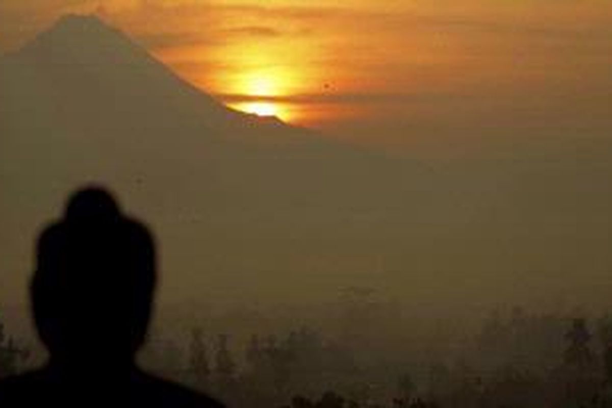 Pemandangan matahari terbit dari balik gunung merapi dengan latar depan stupa budha di Candi Borobudur, Magelang, Jawa Tengah, Rabu (20/4/2011). Wisatawan yang ingin melihat pemadangan matahari terbit harus ada di Candi Borobudur pada pukul 04.30 WIB. Untuk wisatawan lokal dikenakan biaya Rp 220.000 dan wisatawan asing Rp 320.000. 