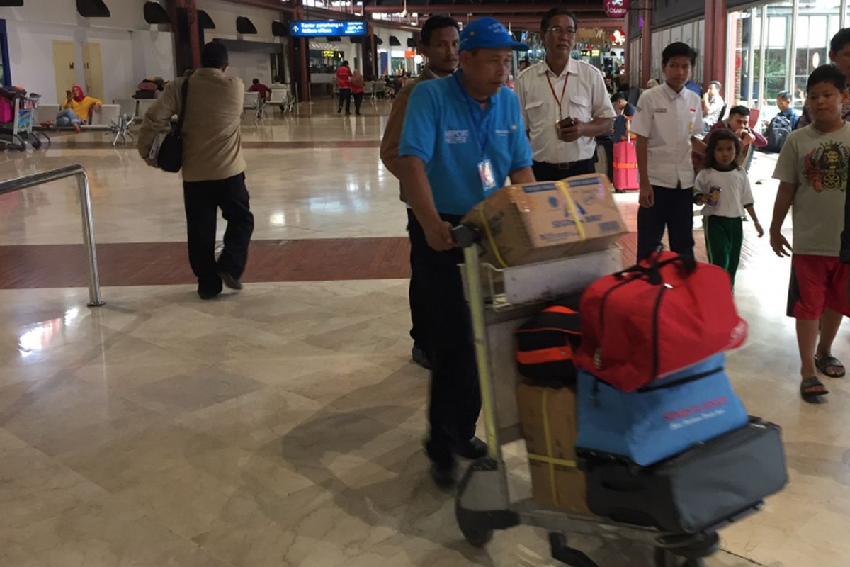 Petugas airport helper sedang membawa barang penumpang dengan troli di Terminal 2 Bandara Soekarno-Hatta, Tangerang, Selasa (10/10/2017). Jasa airport helper diberikan bagi penumpang secara cuma-cuma dan petugas dilarang menerima uang tip dari penumpang. 