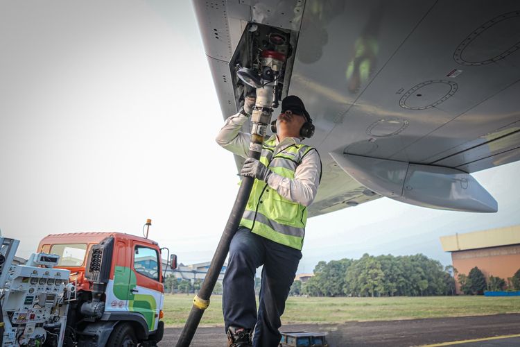 Seorang pekerja sedang mengisi bahan bakar turbin penerbangan (avtur) ke pesawat Garuda Indonesia. 


