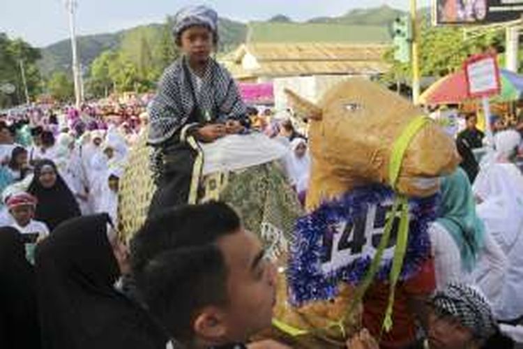 Seorang anak mengendarai patung unta mengikuti pawai Hijraturrasul dalam rangka peringatan Tahun Baru Islam di Kota Gorontalo.