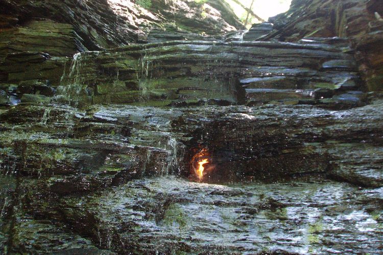 Ilustrasi api abadi dalam gua air terjun Eternal Flame Falls.