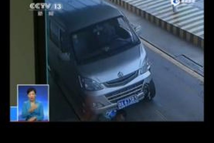 Dalam rekaman CCTV yang disiarkan sebuah stasiun televisi di China terlihat seorang petugas polisi berada di bawah sebuah mobil minibus yang kemudian menyeretnya sejauh 80 meter.