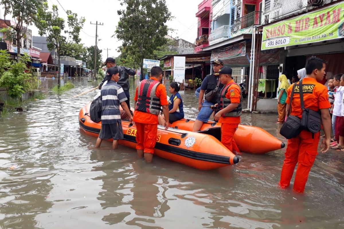 Tim Basarnas Pekanbaru mengevakuasi warga yang dilanda banjir di wilayah Kecamatan Marpoyan Damai, Pekanbaru, Riau, Selasa (11/12/2018).