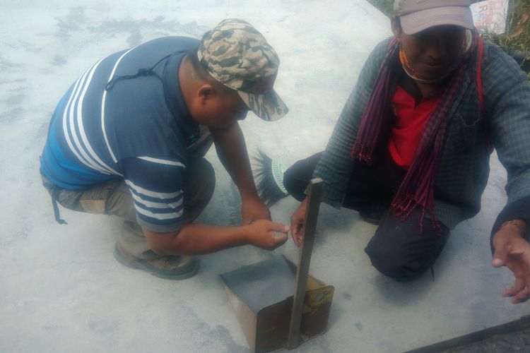 Keponakan mbah Maridjan, Miskam, sedang membersihkan debu dan pasir akibat letusan freatik Merapi bersama relawan lain di Dusun Kinahrejo, Sleman, Jumat (11/5/2018).