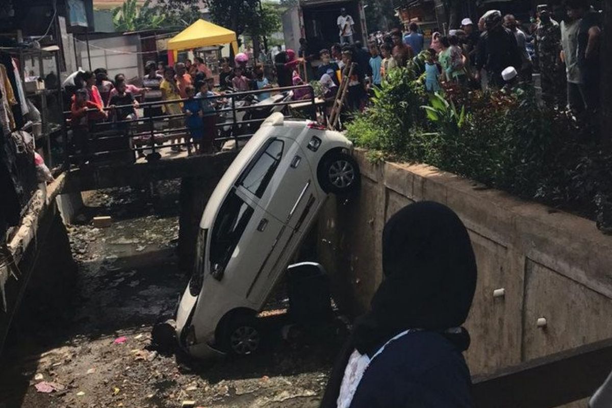 Minibus terperosok ke saluran air di Jalan Mawar Kalisari, Pasar Rebo, Jakarta Timur, Selasa (26/5/2020), akibat pengendara panik. 
