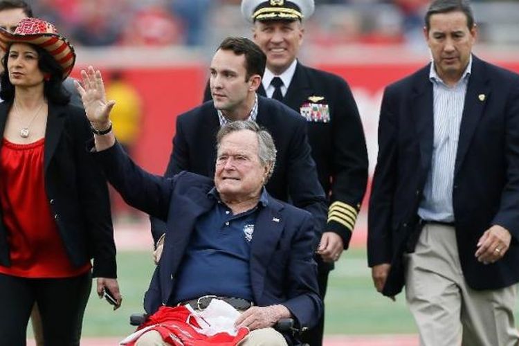 Mantan Presiden AS, George HW Bush, melambaikan tangan kepada kerumunan massa di Stadion TEDECU, November  2015 di Houston, Texas. 
