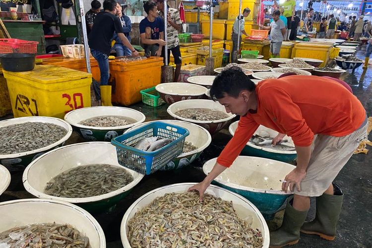 Salah seorang pedagang di Pasar Ikan Muara Angke merapikan udang untuk dijajakan kepada pembeli. 
