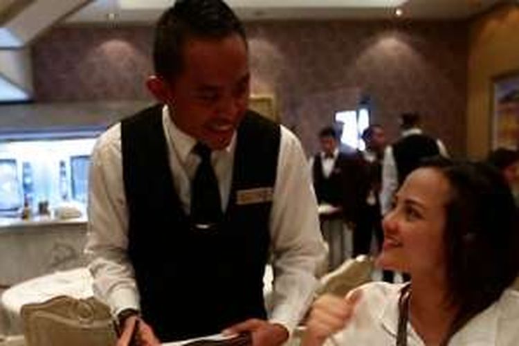 Arief Dananjaya, pramusaji di kapal pesiar Oceania Riviera asal Solo, Indonesia sedang menawarkan menu terbaik di Jacques Restaurant khas Perancis di Riviera.