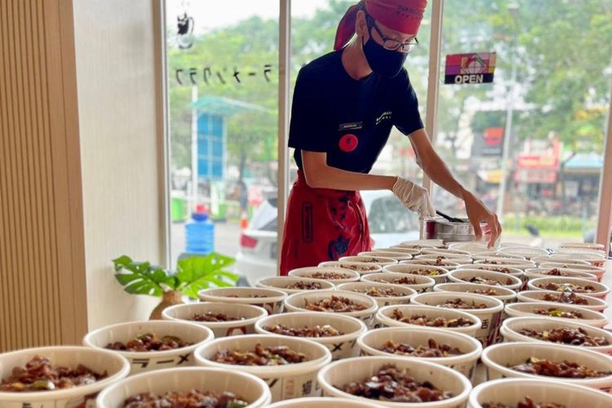 Pegawai Kurabu Ramen yang sedang menyiapkan rice bowl. 