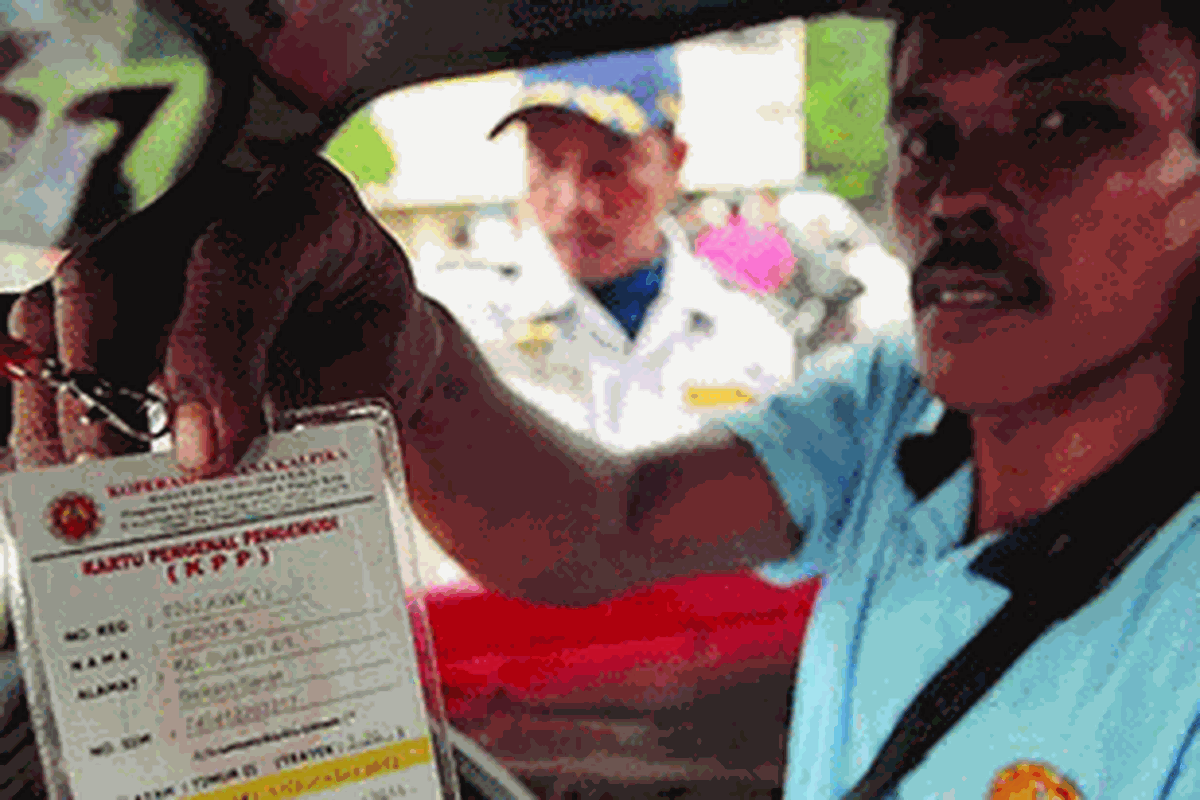 Pengemudi menunjukkan kartu identitas dirinya saat petugas dinas perhubungan melakukan razia identitas dan seragam pengemudi angkutan umum di Terminal Pulo Gadung, Jakarta Timur, Rabu (23/11/2011). Razia tersebut juga merupakan sosialisasi penerapan kewajiban mengenakan identitas dan seragam bagi sopir angkutan umum yang akan diberlakukan mulai Januari 2012.