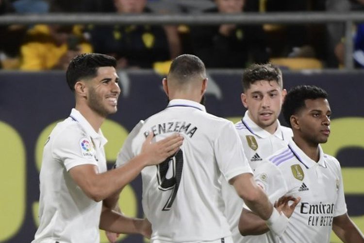 Penyerang Real Madrid, Marco Asensio (kiri), merayakan gol bersama rekan-rekan setimnya dalam laga melawan Cadiz. Laga Cadiz vs Real Madrid pada pekan ke-29 Liga Spanyol 2022-2023 tersebut digelar di Stadion Nuevo Mirandilla pada Sabtu (15/4/2023) malam waktu setempat. (Foto oleh CRISTINA QUICLER / AFP)