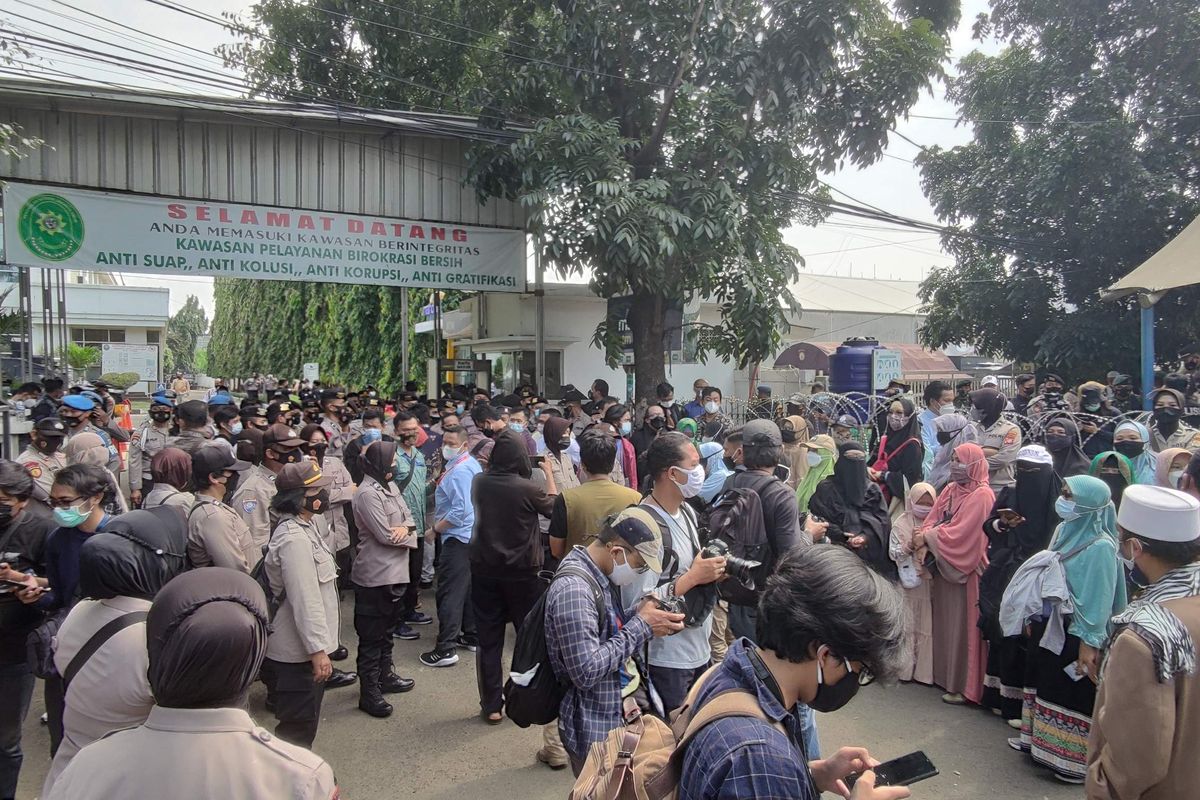 Polisi dan massa berkumpul di PN Jaktim saat sidang dengan terdakwa Rizieq Shihab, Jumat (19/3/2021).