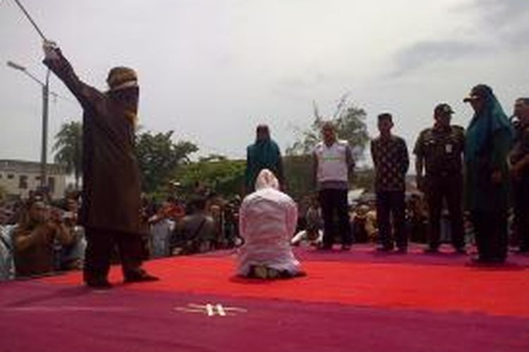 Seorang terpidana cambuk melanggar qanun nomor 14/2003 menjalani hukuman cambuk sebanyak 5 kali cambuk di hadapan khalayak umum di Depan Mesjid Baitusshalihin Ulee Kareng, Banda Aceh, Jumat (18/9/2015). Sebanyak 18 terpidana cambuk menjalankan eksekusi dihari yang sama di Banda Aceh.