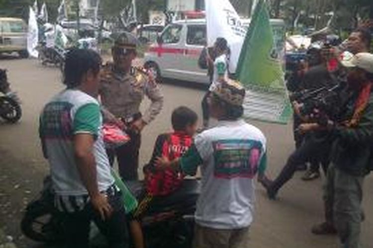 Masa peserta pendukung Partai Kebangkitan Bangsa (PKB) yang hendak mengikuti kegiatan kampanye di Lapangan Pacuan Kuda, Pulomas, Pulogadung, Jakarta Timur ditilang petugas polisi lalu lintas. Senin (24/3/2014). 