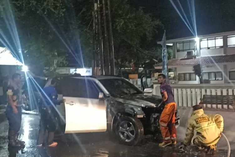 Petugas Pemadam Kebakaran dari BPBD Karawang tengah memadamkan api yang keluar dari bagian depan sebuah mobil di depan Kantor BPN/ATR Karawang, Jawa Barat, Senin (6/2/2023)