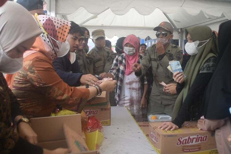 Ratusan warga kota Baubau, Sulawesi Tenggara, berdesak-desakan dalam pasar murah yang digelar Dinas Perindustrian dan Perdagangan (Disperindag) kota Baubau, Kamis (31/3/ 2022) siang. Dalam pasar murah tersebut, warga menyerbu minyak goreng dengan harga yang murah dari pasaran.