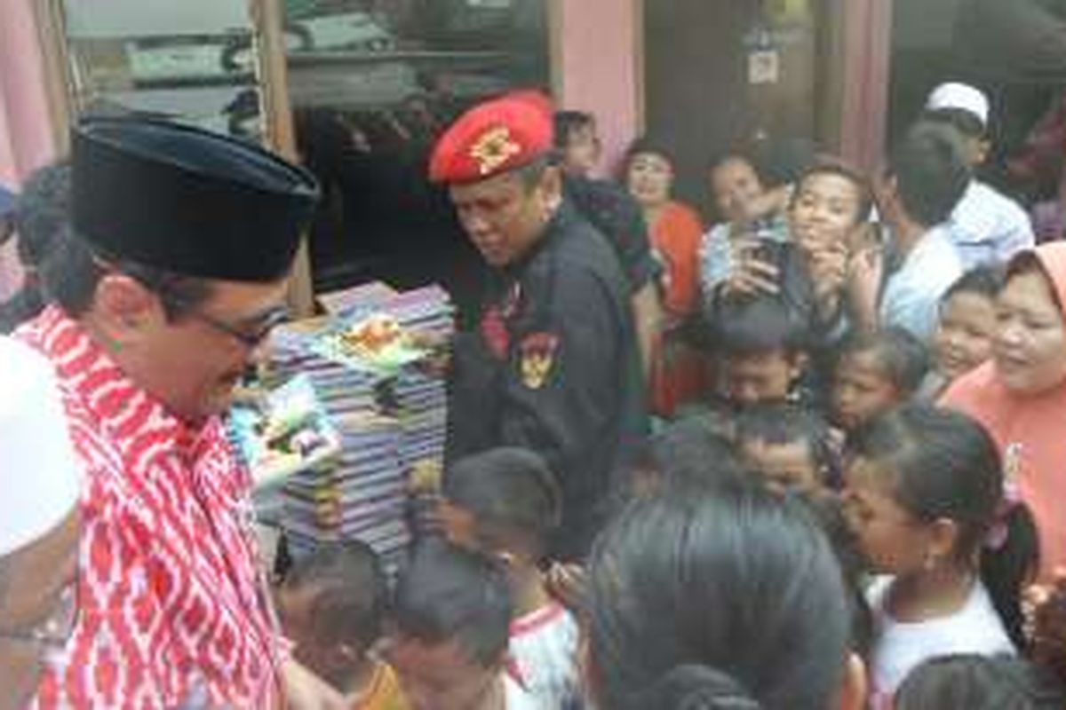 Wakil Gubernur DKI Jakarta Djarot Syaiful Hidayat membagikan buku tulis kepada anak-anak di Kebon Kacang, Kemayoran, Jumat (24/6/2016). 