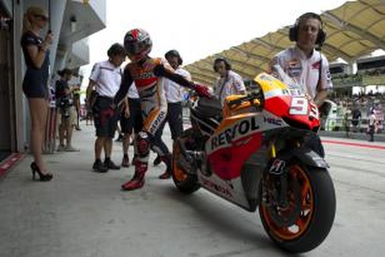 Pebalap MotoGP dari tim Repsol Honda, Marc Marquez, berjalan ke dalam garasi pada sesi latihan keempat Grand Prix Malaysia di Sirkuit Internasional Sepang, Sabtu (12/10/2013).