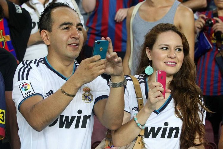 Pendukung Real Madrid yang tengah berada di kerumunan pendukung Barcelona saat pertandingan kedua tim di Stadion Camp Nou, Barcelona.