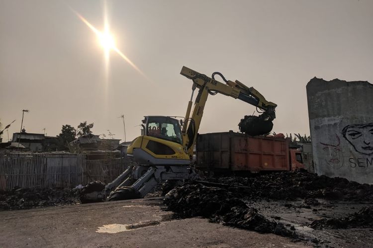 Alat Berat milik Pemerintah Kota Jakarta Utara mengeruk lumpur hitam yang berisikan berbagai jenis sampah hasil buangan warga Kampung Bengek selama bertahun-tahun. Pembersihan dilakukan Rabu (4/9/2019).