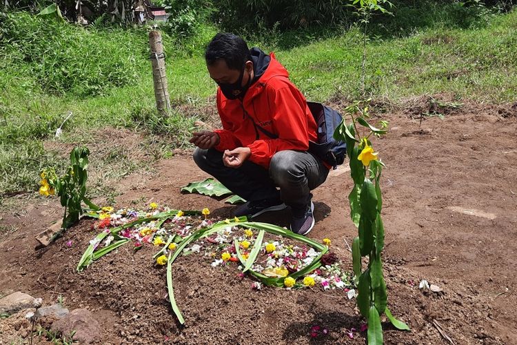 Salah seorang keluarga korban siswa SD yang meninggal usai divaksin di Kota Tasikmalaya sedang berdoa di pamakaman korban di Kecamatan Purbaratu, Kota Tasikmalaya, Selasa (18/1/2022).