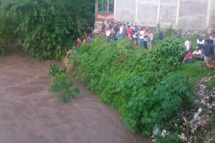 Warga saat membantu proses pencarian korban yang hanyut terseret banjir di Dompu, Selasa (11/11/2022).