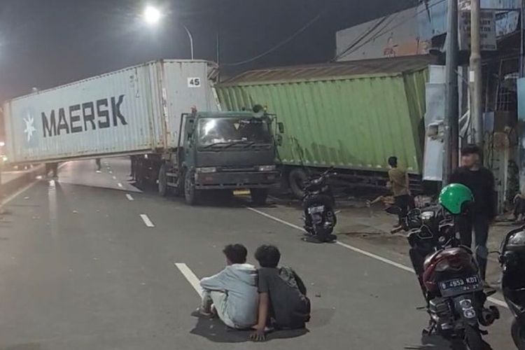 Sebuah truk kontainer bernomor polisi B 3438 JG mengalami kecelakaan hingga menabrak truk yang sedang terparkir di pinggir jalan dan juga warung makan di Jalan Sultan Agung, Kecamatan Medan Satria, Kota Bekasi, Jawa Barat, Kamis (27/6/2024) dini hari.