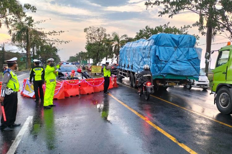 Jajaran kepolisian berjaga dan mengatur arus lalu lintas di Jalan Raya Pantura, Jalan Nasional yang menghubungkan Lamongan-Gresik.