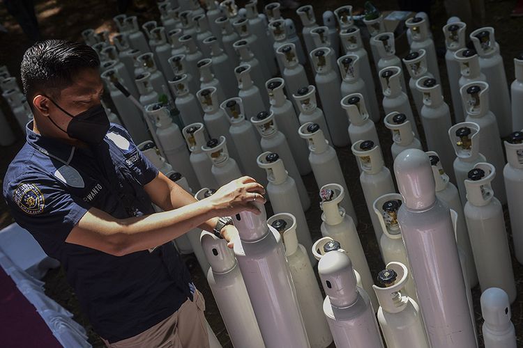 A police personnel is arranging confiscated oxygen cylinders before the handing over of the items to the Jakarta Administration on Tuesday, July 27, 2021.  