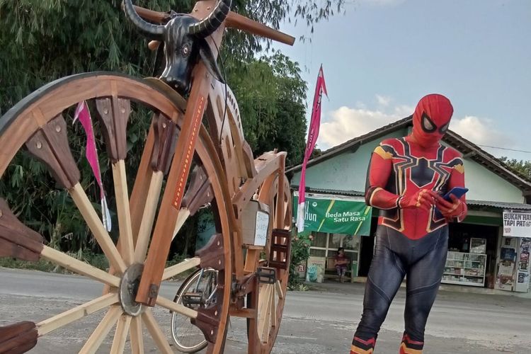Sarijo (50), warga RT 013, RW 006 Desa Tambakan, Kecamatan Jogonalan, Kabupaten Klaten, Jawa Tengah gowes sepeda kayu raksasa buatannya dengan memakai kostum spiderman, Senin (15/8/2022).