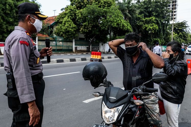 Petugas gabungan dari TNI, Polri, Polisi Pamong Praja dan Dishub DKI Jakarta melakukan imbauan kepada pengendara motor untuk dapat mematuhi penerapan Pembatasan Sosial Berskala Besar (PSBB) di jalan Penjernihan, Tanah Abang, Jakarta Pusat, Senin (13/4/2020). Imbauan ini dilakukan agar masyarakat menerapkan pembatasan sosial berskala besar (PSBB) selama 14 hari, yang salah satu aturannya adalah pembatasan penumpang kendaraan serta anjuran untuk menggunakan masker jika berkendara.