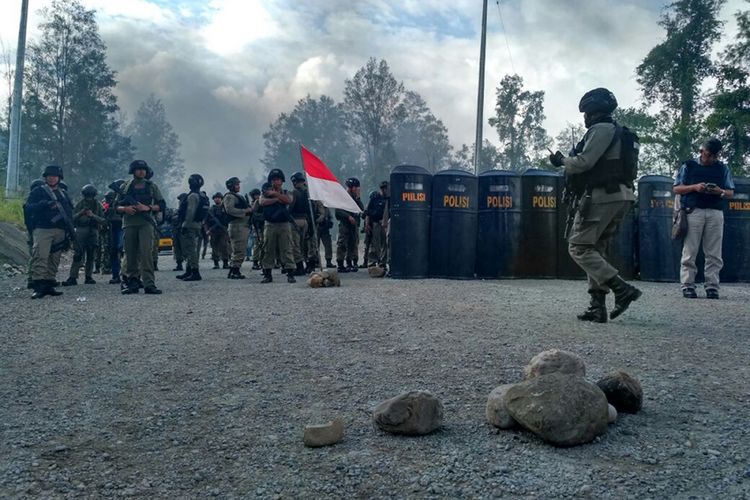 Personil kepolisian berjaga di lokasi unjuk rasa karyawan korban PHK PT Freeport Indonesia di Check Point Mile 28, Timika, Papua, Sabtu (19/8/2017). Karyawan korban PHK tersebut kecewa karena persoalan hubungan industrial antara pekerja dan manajemen PT Freeport Indonesia tidak kunjung selesai.