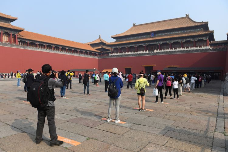 Warga mengantre dengan menjaga jarak saat mereka mengunjungi kawasan wisata Forbidden City. Setelah sempat menjalani masa karantina akibat penyebaran Covid-19, jutaan orang di China kembali turun ke jalan dan mengunjungi kawasan wisata yang kembali dibuka.