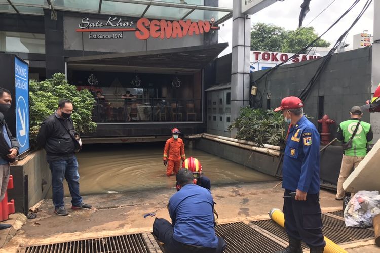 Anggota Sektor X Jagakarsa Suku Dinas Penanggulangan Kebakaran dan Penyelamatan Jakarta Selatan menyiapkan selang untuk menyedot banjir di area basement Sate Khas Senayan Kemang, Bangka, Mampang Prapatan, Jakarta Selatan pada Minggu (21/2/2021) siang.