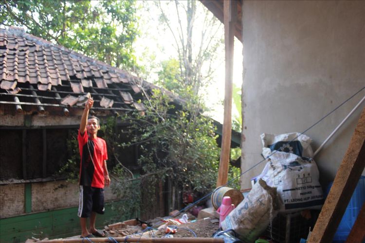 Seorang warga di Kampung Pasir Peso, Cibeber, Kabupaten Cianjur, Jawa Barat memerlihatkan dinding rumahnya yang ambruk akibat guncangan gempa Banten magnitudo 6.9 Jumat malam kemarin.