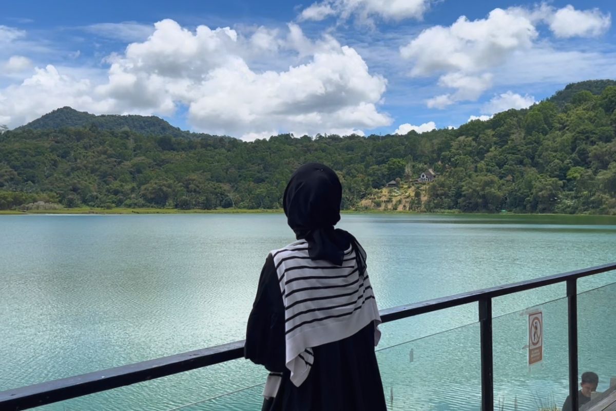 Potrait wisatawan sedang melihat panorama Danau Linow, Sulawesi Utara, Jumat (31/10/2025). 