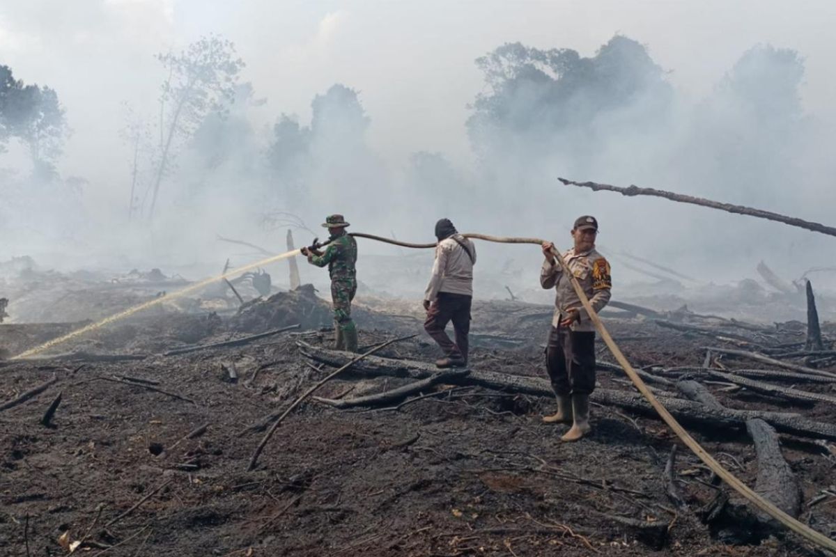 Petugas kepolisian dan TNI saat melakukan pemadaman titik api karhutla, di Kecamatan Bandar Laksamana, Kabupaten Bengkalis, Riau, Rabu (27/3/2024).