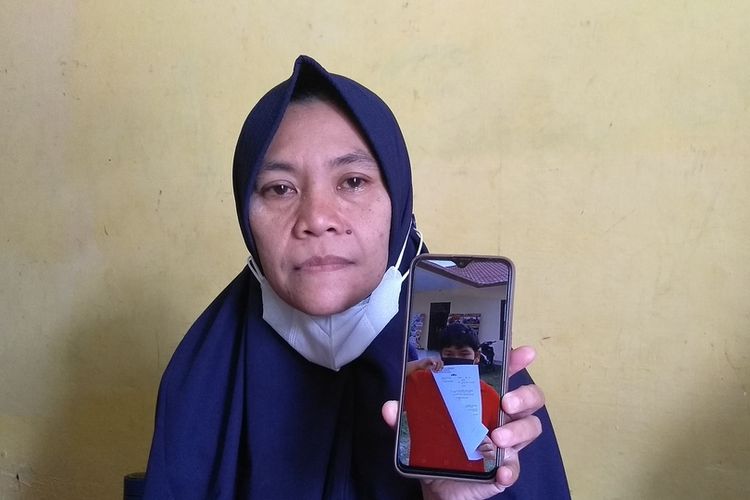 Lia Pratiwi (42) menunjukkan foto anaknya, M. Reza Aulia (10) membawa berkas laporan di Polsek Tuntungan pada Jumat (11/6/2021). Sebelum meninggal dunia pada Minggu (13/6/2021), Reza digigit anjing pada Kamis (10/6/2021). Kondisinya dari hari ke hari semakin memburuk. Pihak keluarga membuat laporan ke polisi lantaran tidak ada itikad baik dari pemilik anjing.