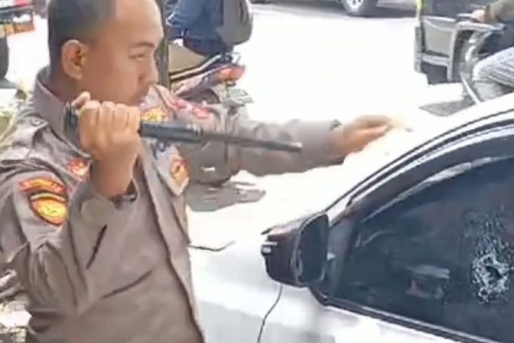Aipda Donny Yanuar saat memecahkan kaca mobil untuk menolong balita yang terkunci, Selasa (2/4/2024) pagi.