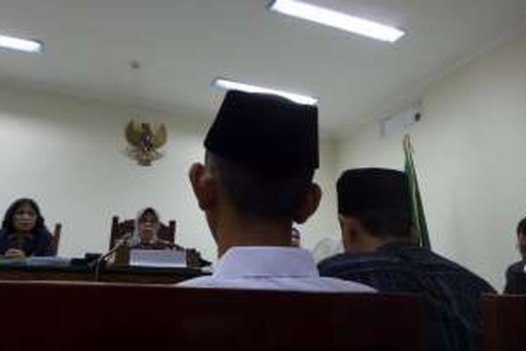 Remaja terdakwa kasus pembunuhan karyawati EF (19), RA (16), mendengarkan putusan di Pengadilan Negeri Tangerang, Kamis (16/6/2016). Pada sidang putusan ini, RA didampingi ayahnya, Nayudin, yang duduk di sampingnya. 