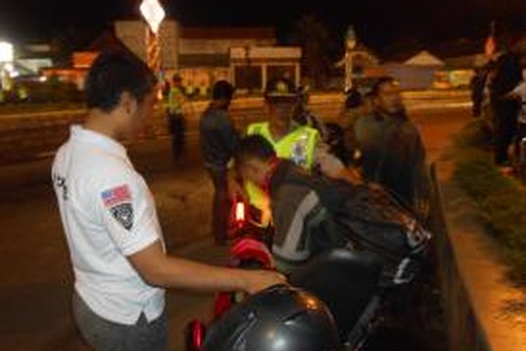 Petugas memeriksa pengendara motor saat operasi begal di alun-alun Demak, Sabtu (15/3/21015)