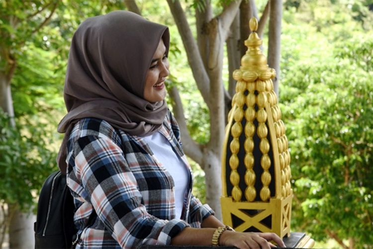 Seorang pengunjung melihat miniatur tolangga yang menghiasi Masjid Walima Emas di Desa Bongo, Kecamatan Batudaa Pantai, Kabupaten Gorontalo. Masjid Walima Emas menjadi salah satu destinasi wisata di Desa Bongo.